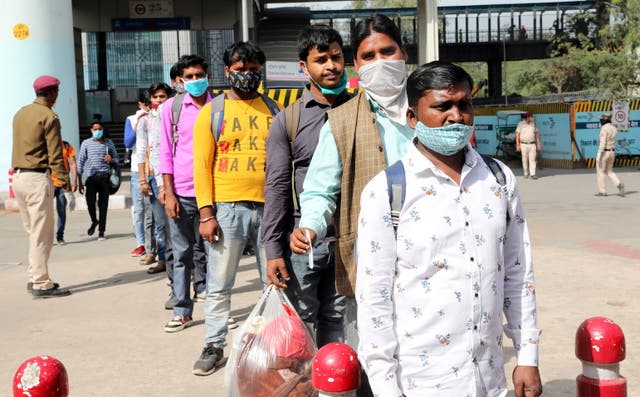 <p>People wait to undergo a Covid-19 swab test at the Anand Vihar bus station in Delhi, 8 April 2021</p>
