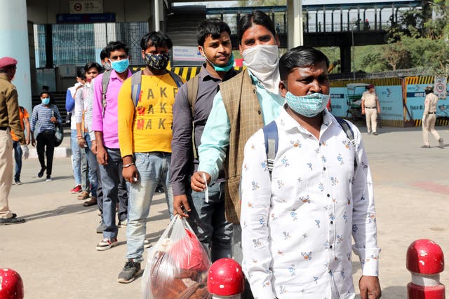 <p>People wait to undergo a Covid-19 swab test at the Anand Vihar bus station in Delhi, 8 April 2021</p>