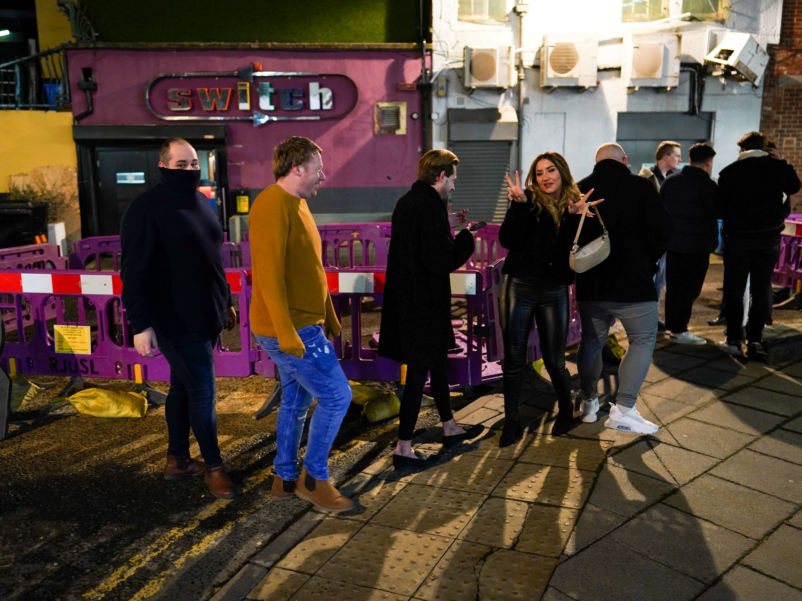 Customers wait outside the Switch bar in Newcastle as it prepares to serve customers after midnight to mark the latest lifting of lockdown measures