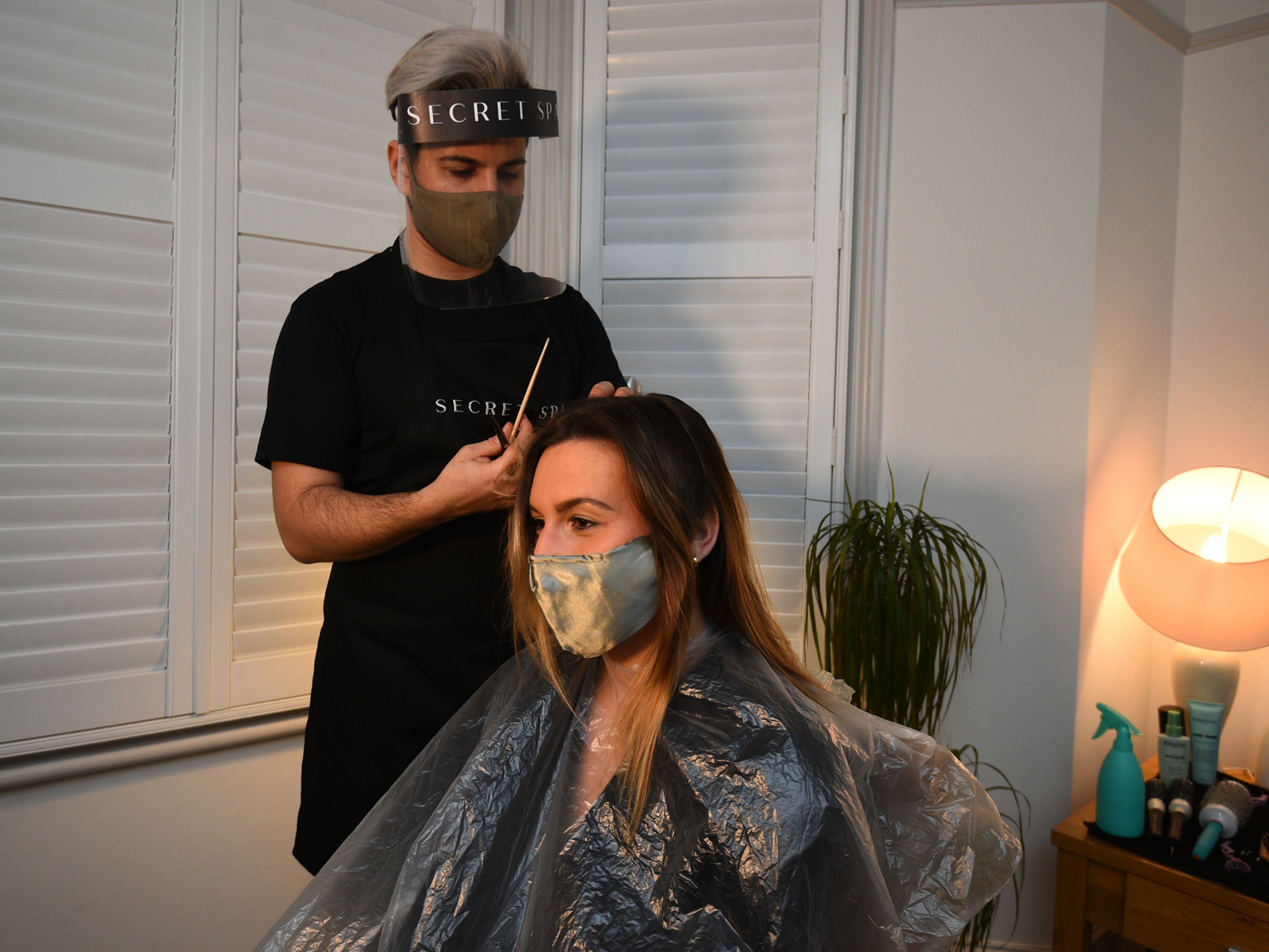 Secret spa hair stylist Nas Ganev cuts the hair of Amy Pallister, 27, just after midnight at her home in Balham, south London