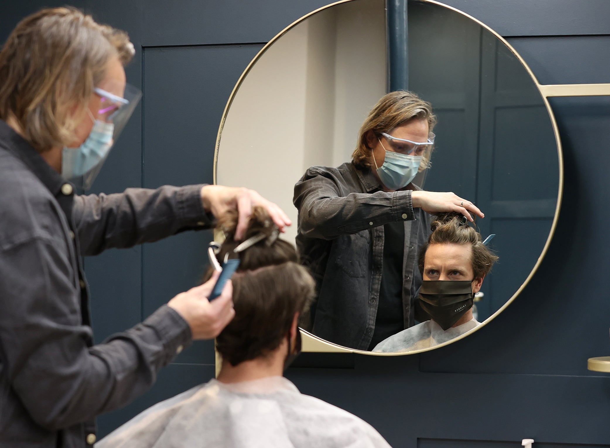 Owner of Trinder Hair Studios, Marc Trinder cuts the hair of his first customer Simon Amphlett after the easing of lockdown restrictions in St Albans, England