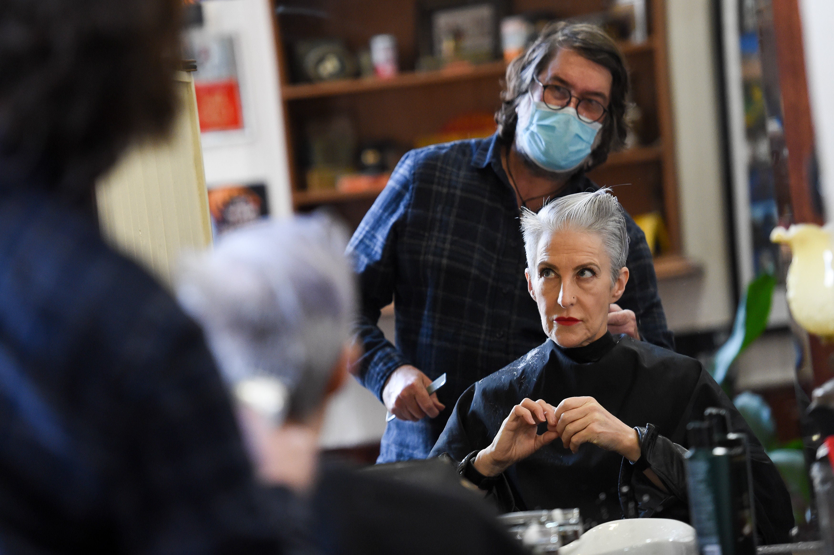 A woman has her hair cut at the reopening of Jakes Barbers, in Birmingham
