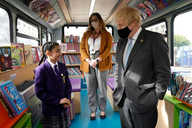 Boris Johnson speaks to a primary school student onboard a bus library during a visit to St Mary’s CE Primary School last month in Stoke-on-Trent