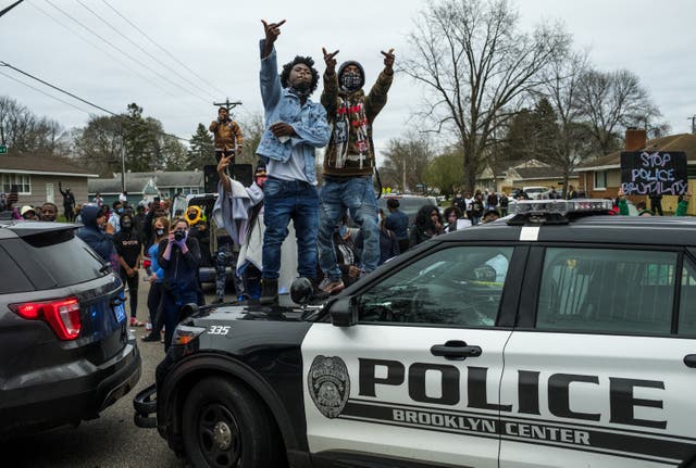 <p>People stand on a police cruiser as protesters take to the streets after Brooklyn Center police shot and killed Daunte Wright during a traffic stop on April 11, 2021 in Brooklyn Center, Minnesota.</p>