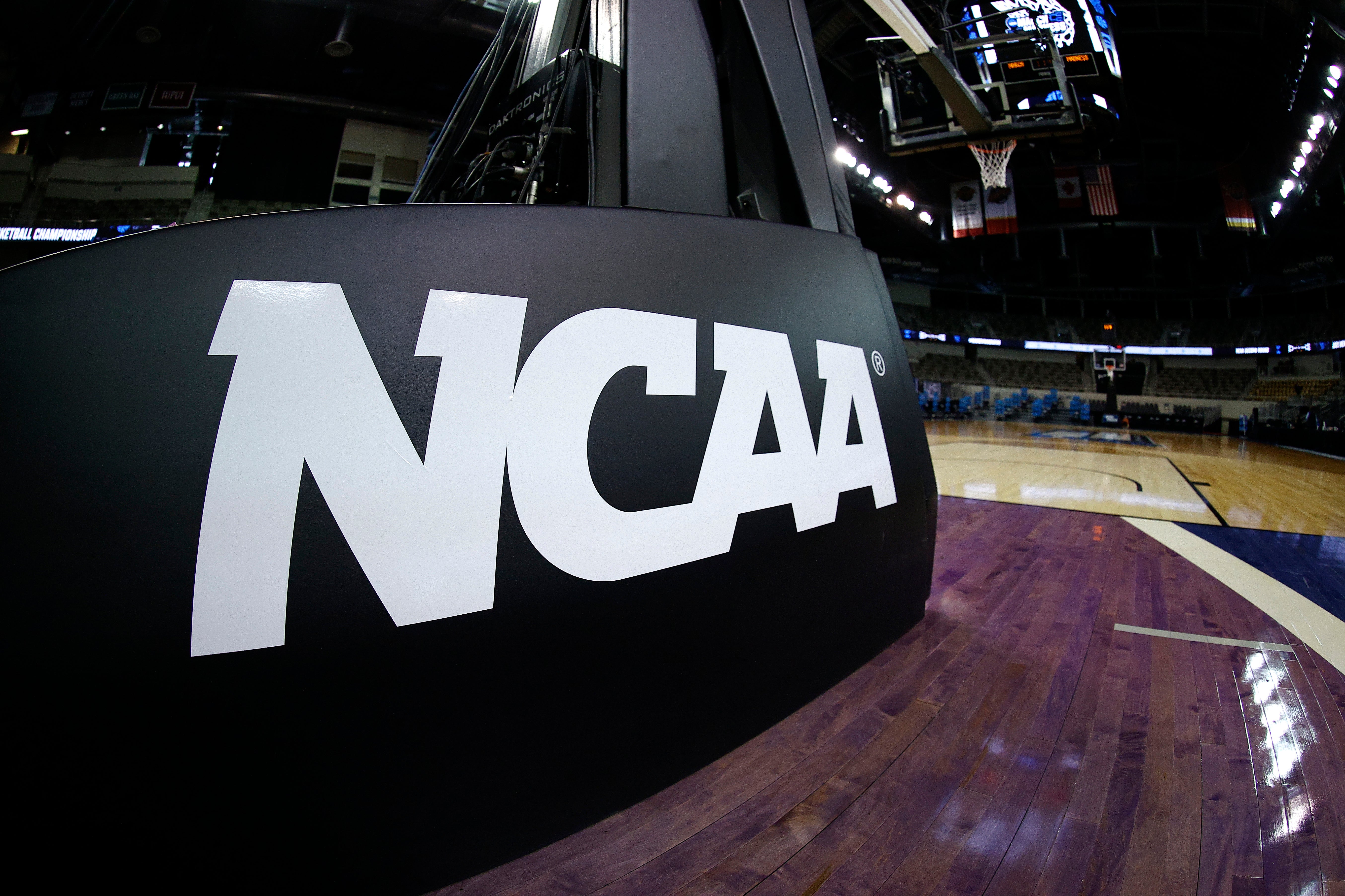 <p>The NCAA logo is seen on the basket stanchion before the game between the Oral Roberts Golden Eagles and the Florida Gators in the second round game of the 2021 NCAA Men's Basketball Tournament at Indiana Farmers Coliseum on March 21, 2021 in Indianapolis, Indiana.</p>