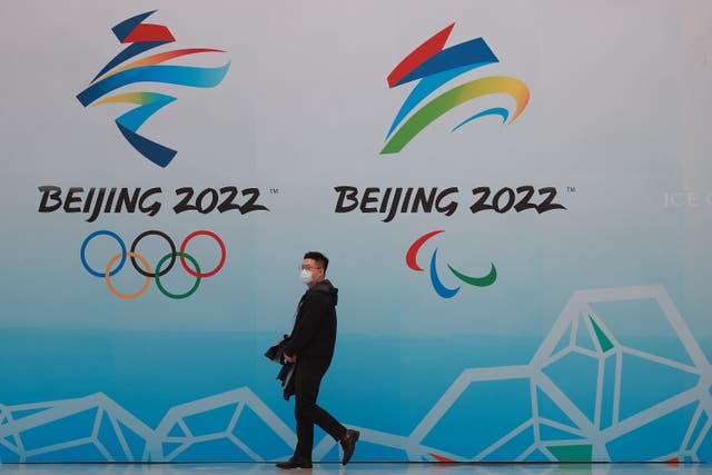 <p>A man walks in front of the logos of the 2022 Beijing Winter Olympics at National Aquatics Centre on 9 April 2021 in Beijing</p>