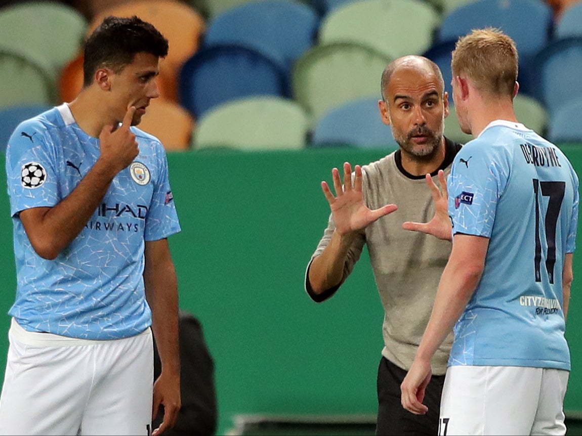 Pep Guardiola talks to Manchester City players Rodri and Kevin De Bruyne