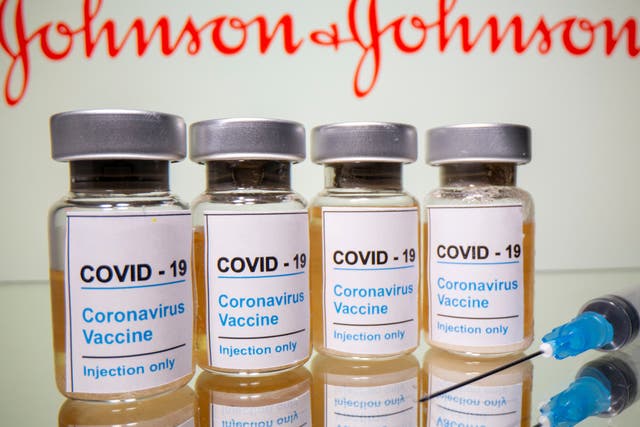 En esta ilustración, tomada el 31 de octubre de 2020, se ven viales con una etiqueta que dice 'Covid-19 / Vacuna contra el coronavirus / Inyección solamente' y una jeringa médica frente a un logotipo de Johnson & Johnson mostrado.
