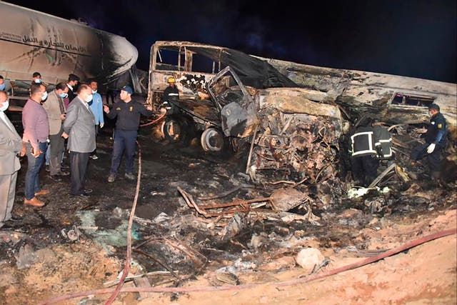 Investigators at the collision site where a bus overturned and burst into flames, killing 20 people, near Assuit, in southern Egypt.