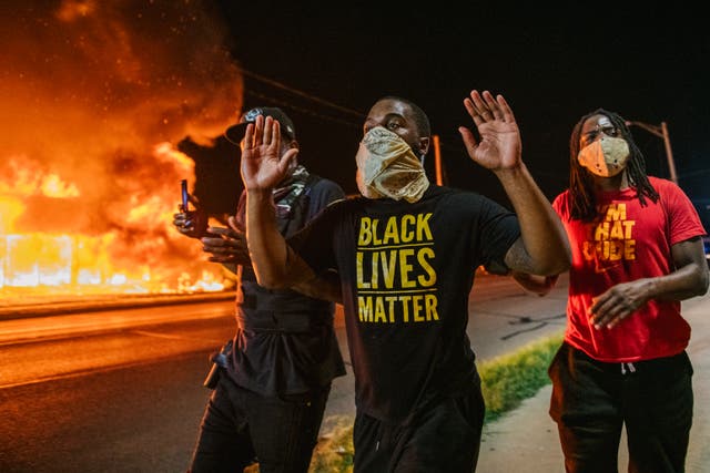 <p>Men walk towards law enforcement with their hands up on August 24, 2020 in Kenosha, Wisconsin. A second night of civil unrest occurred after the shooting of Jacob Blake, 29, on August 23.</p>