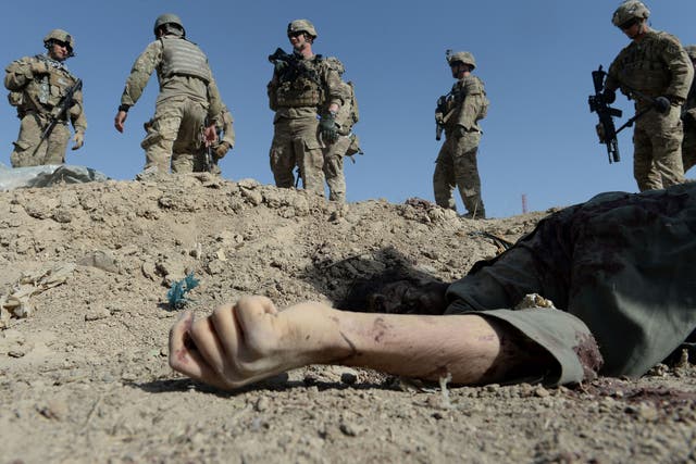US soldiers over the dead body of an insurgent after a suicide attack in Afghanistan in 2013