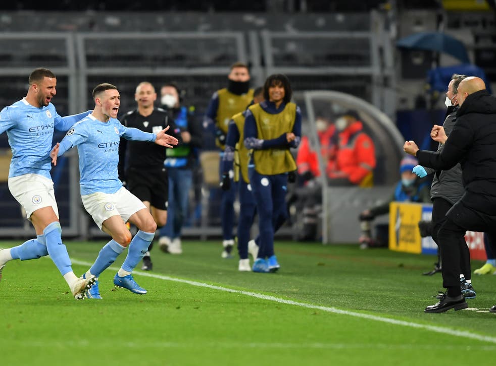Phil Foden runs to celebrate with coach Pep Guardiola after scoring for City