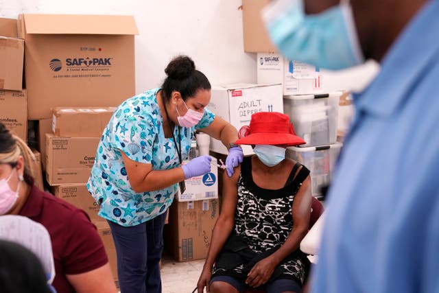 La enfermera registrada Ashleigh Velasco, a la izquierda, administra la vacuna Johnson & Johnson COVID-19 a Rosemene Lordeus, a la derecha, en una clínica de Healthcare Network en Immokalee, Fla.