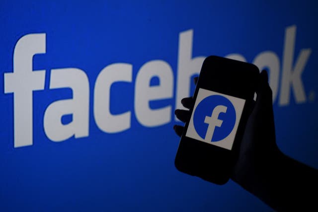 Smartphone screen displaying Facebook logo on a Facebook website background