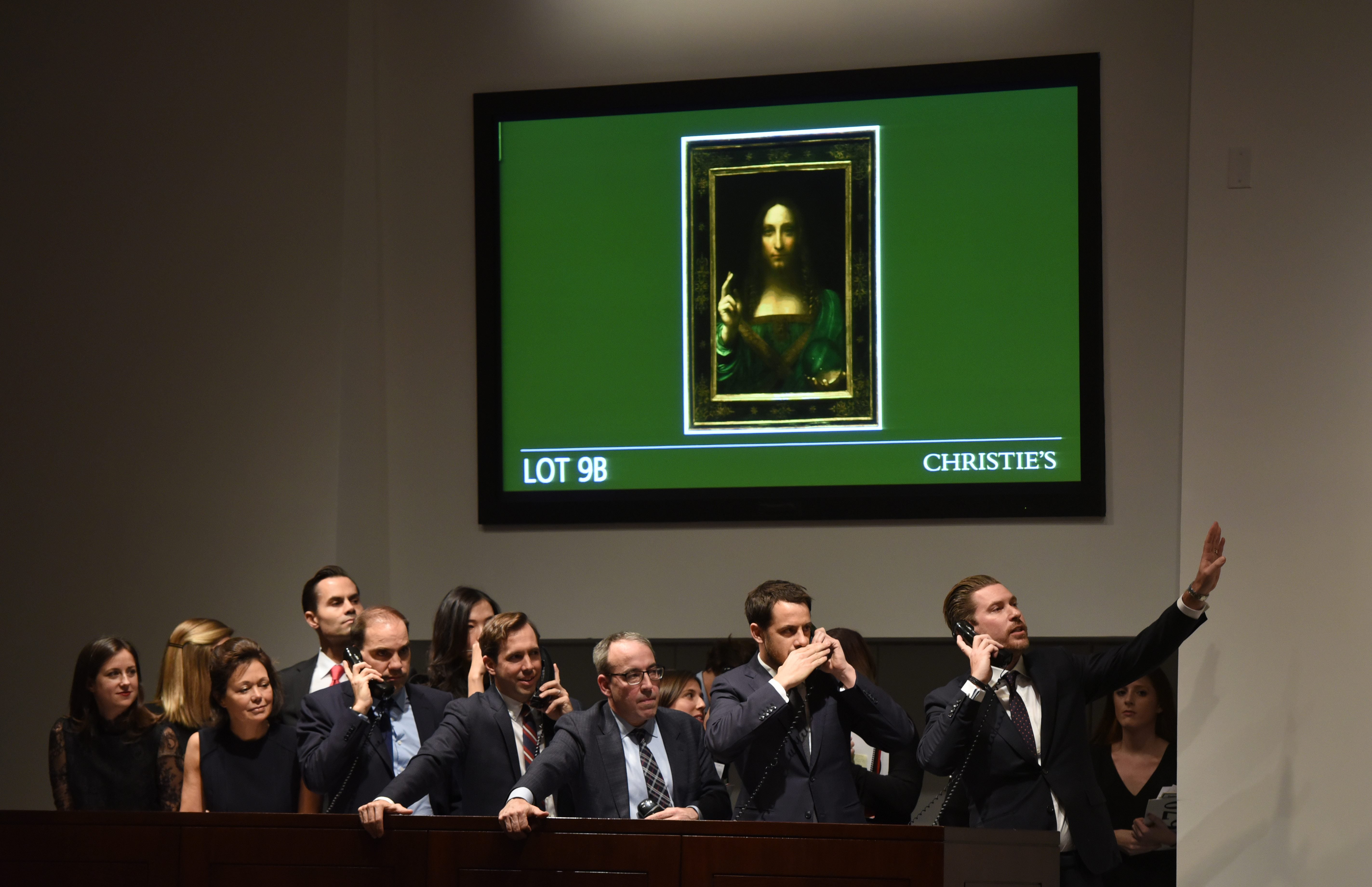 Employees at Christie’s take bids for the painting