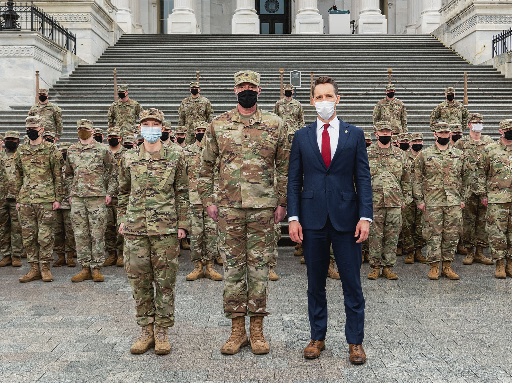 <p>Missouri senator Josh Hawley posing with National Guard troops from his state</p>