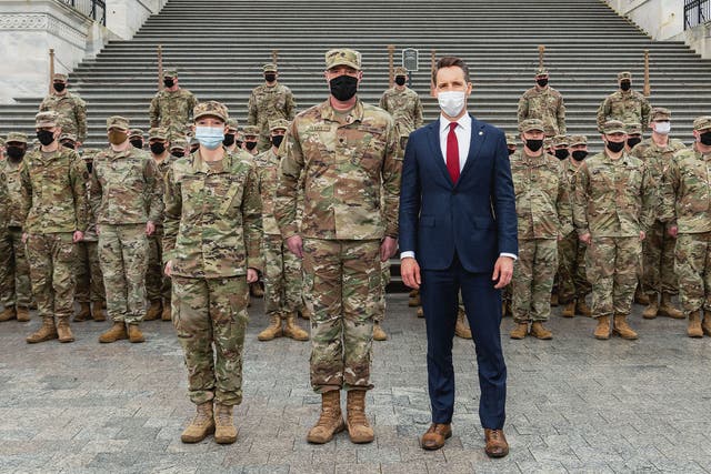 <p>Missouri senator Josh Hawley posing with National Guard troops from his state</p>