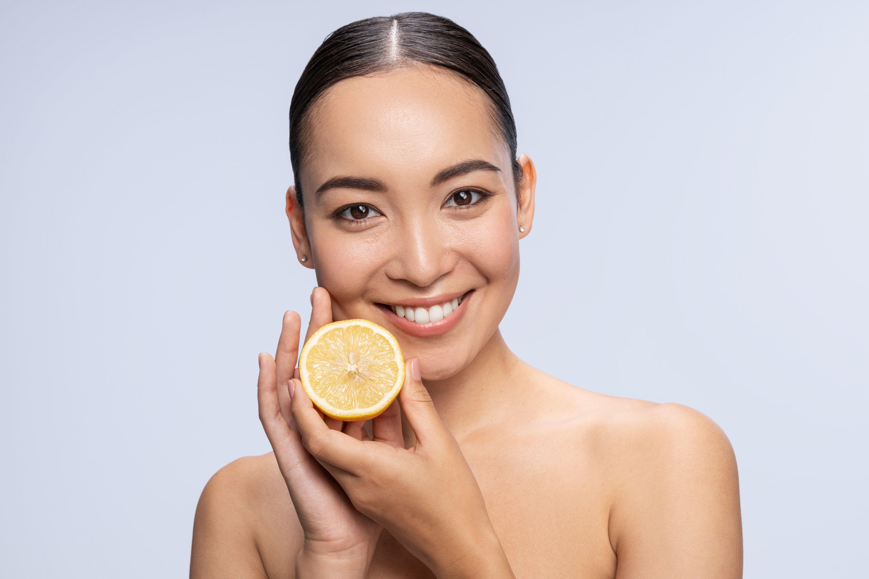woman holding a cut lemon