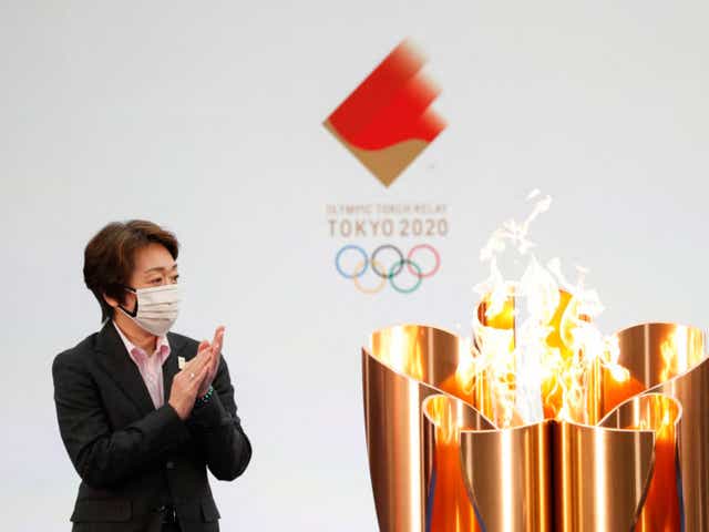 Tokyo 2020 President Seiko Hashimoto applauds next to the celebration cauldron