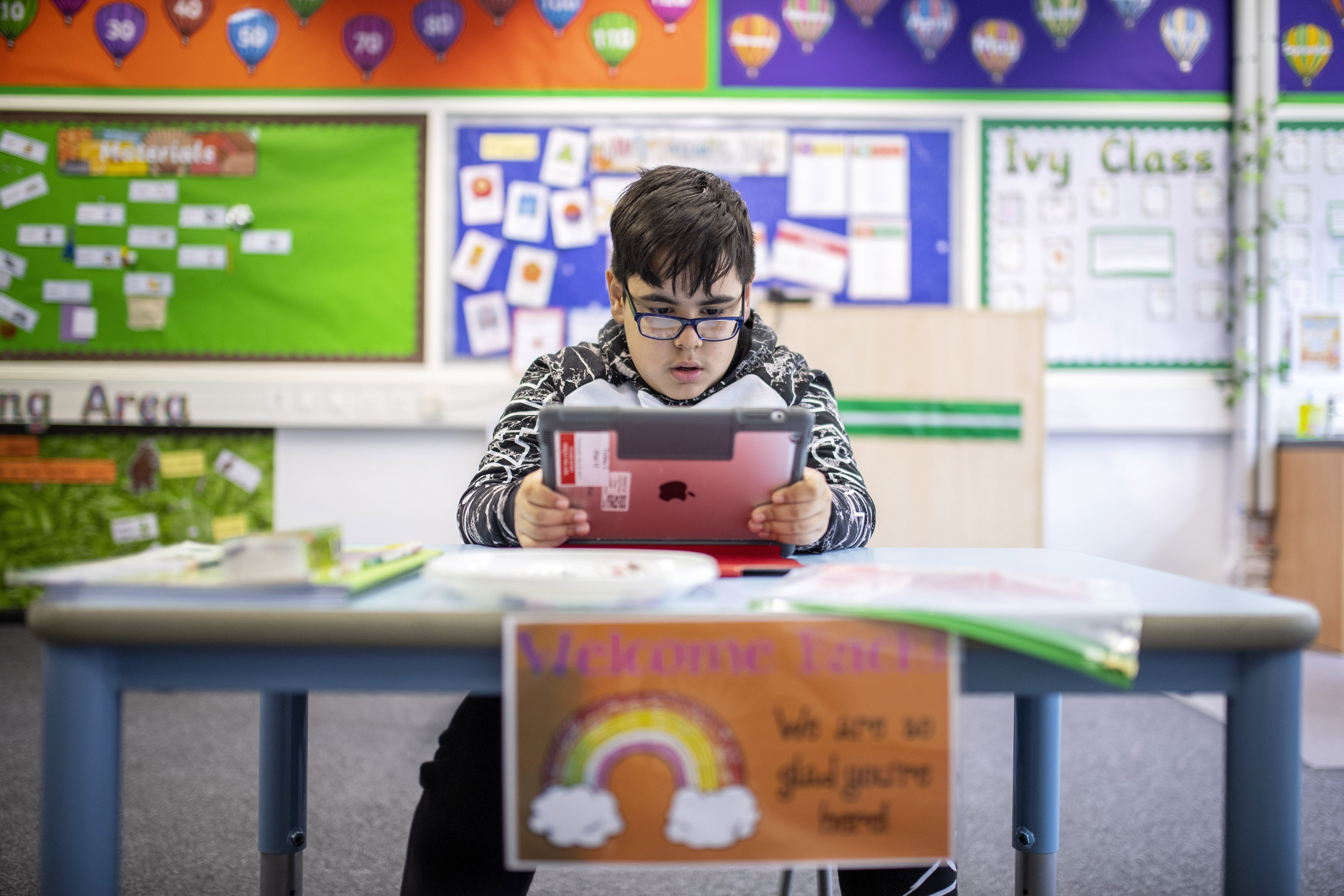 A child maintains social distancing measures while taking part in a lesson at Earlham Primary School in London, England