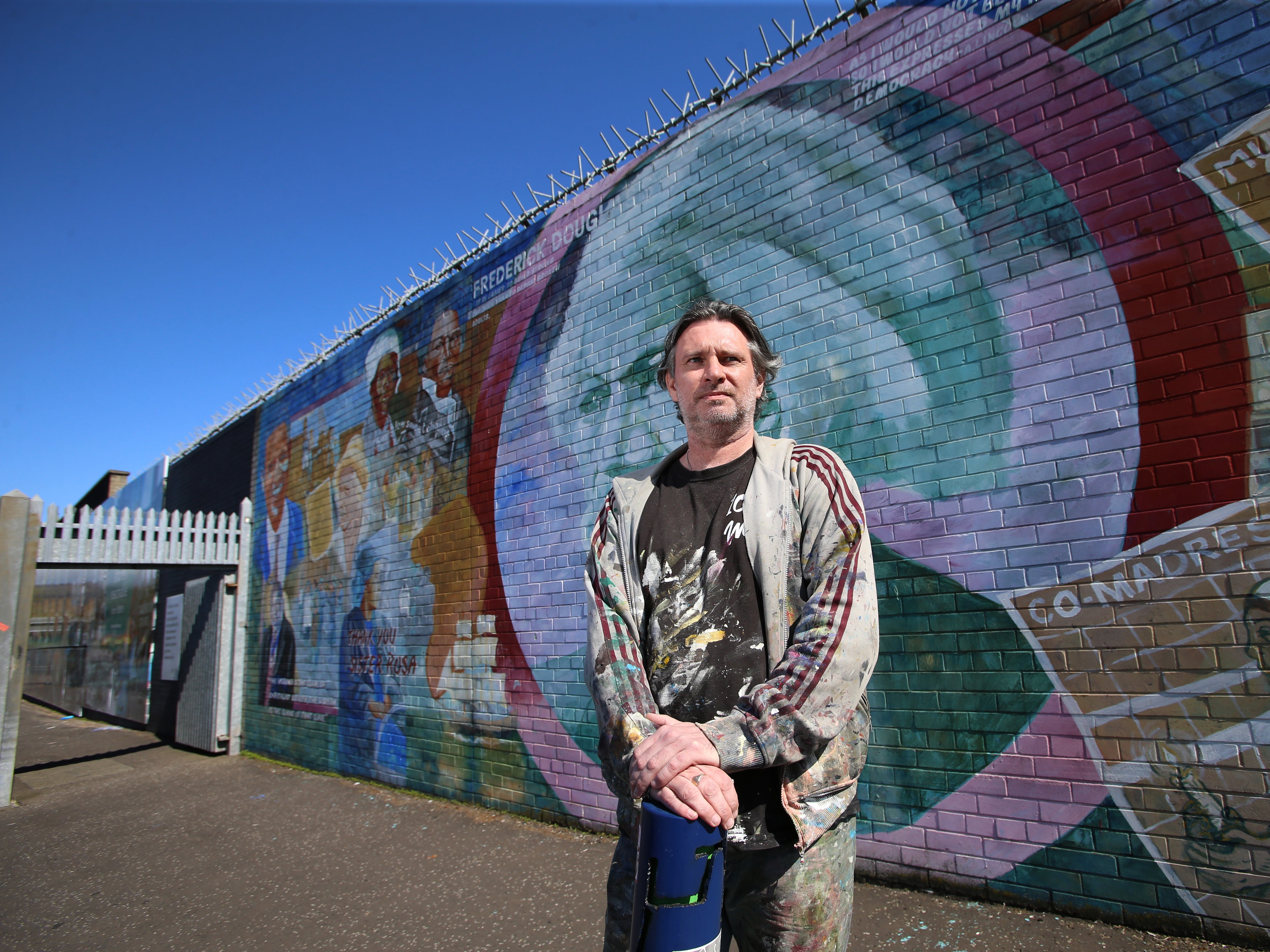 Mark Ervine, street artist and son of the late Progressive Unionist Party (PUP) leader David Ervine, stands near a mural he worked on on the peace line in West Belfast