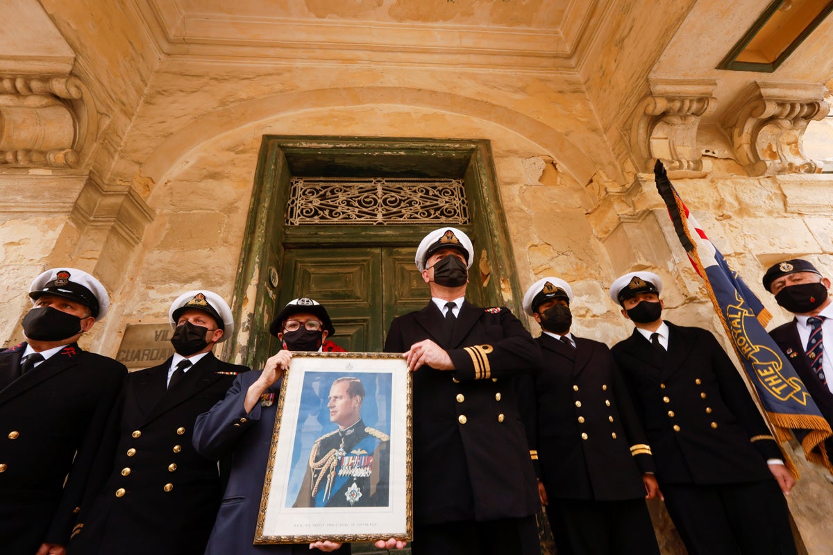 Reenactor members of the Malta Command WW2 Living History Group and Ex Royal Navy WREN officer Elaine Zerafa, Secretary of the Royal Naval Association (Malta Branch) hold a picture of Prince Philip to honour him before his funeral, outside Villa Guardamangia, a former residence of Britain's then-Princess Elizabeth and Prince Philip between 1949 and 1951, in Pieta, Malta