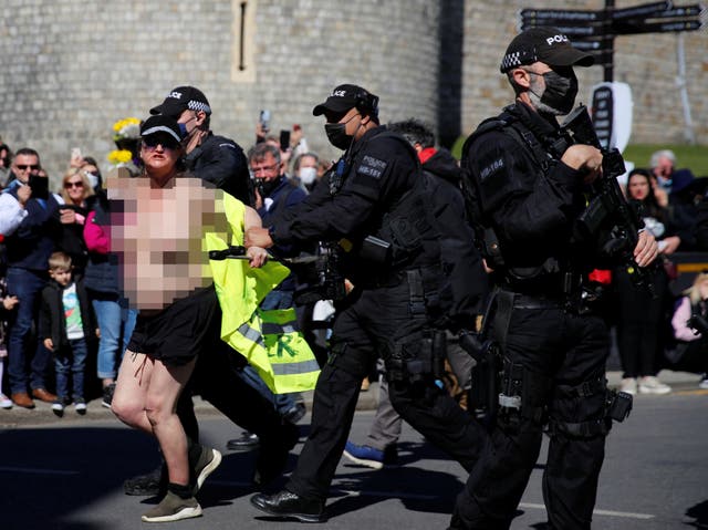 A protester runs outside Windsor Castle on the day of the funeral of Prince Philip