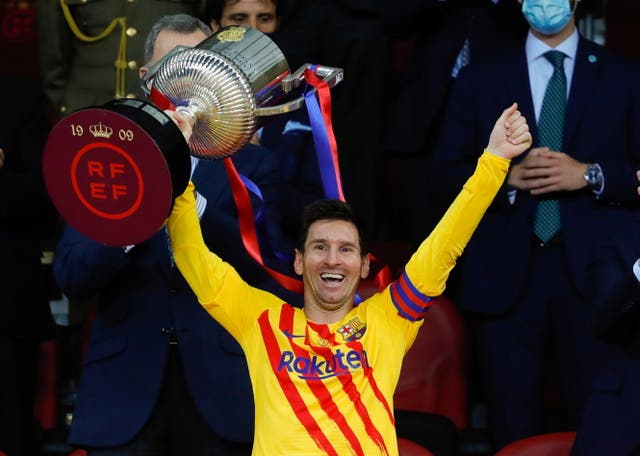 Lionel Messi celebrates with the trophy