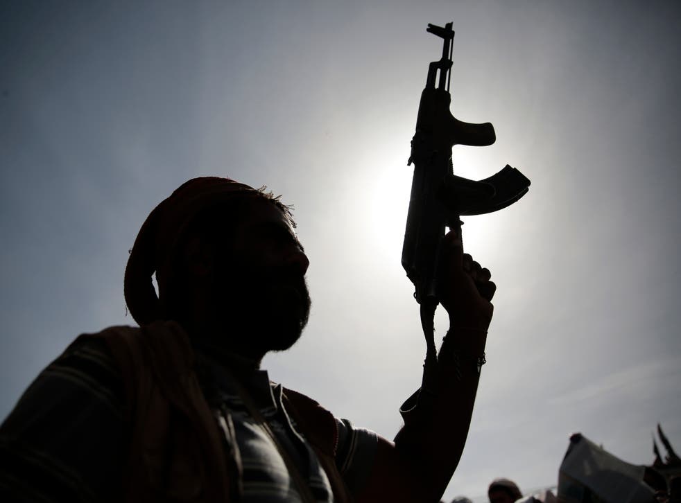 A silhouette of a Houthi supporter holds his weapon during a rally last month
