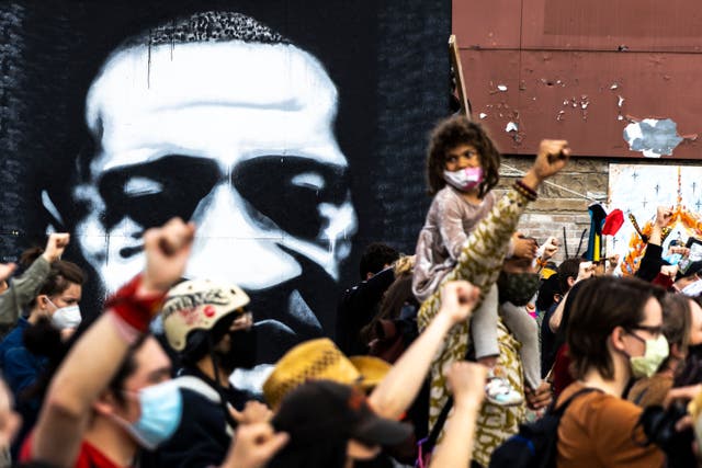 <p>People raise their fists during a demonstration near the George Floyd Memorial in Minneapolis, Minnesota on April 18, 2021 after the shooting death of Daunte Wright.</p>