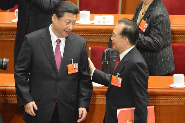 <p>Xi Jinping talks to former Chinese premier Wen Jiabao after the closing session of the National People’s Congress in Beijing on 17 March 2013</p>