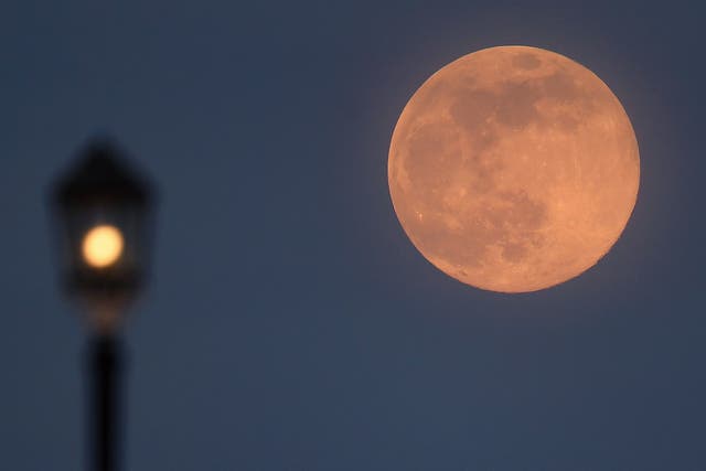  A supermoon rises over Worthing pier on 7 April, 2020 in Worthing, United Kingdom