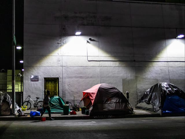 <p>A homeless man is seen among tents on the street of Skid Row during the Covid-19, Coronavirus pandemic in Los Angeles, California on 16 May 2020</p>