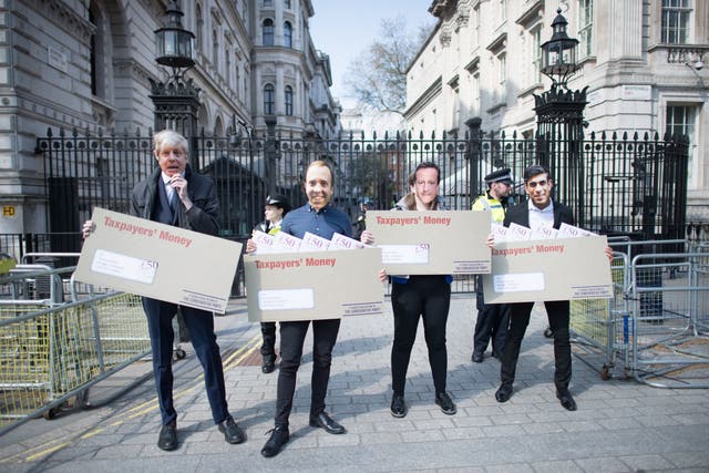<p>Labour activists wearing face masks, depicting Boris Johnson, Rishi Sunak, Matt Hancock and David Cameron, carry oversized envelopes addressed to ‘Tory chums, Dodgy contracts, Jobs for mates’ outside Downing Street, London, today (21 April)</p>
