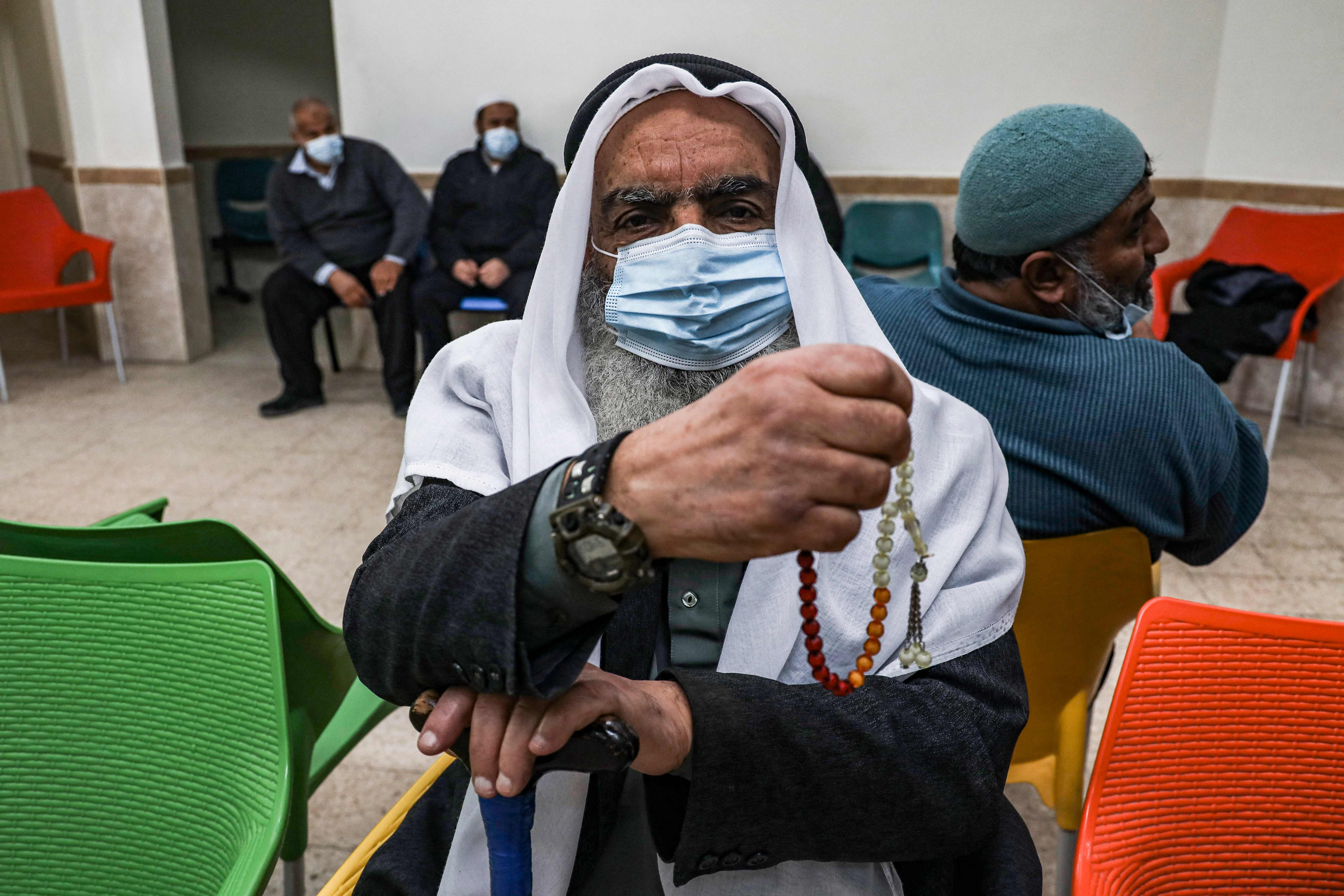 An elderly Palestinian waits to receive a dose of COVID-19 coronavirus vaccine at a clinic in Gaza City