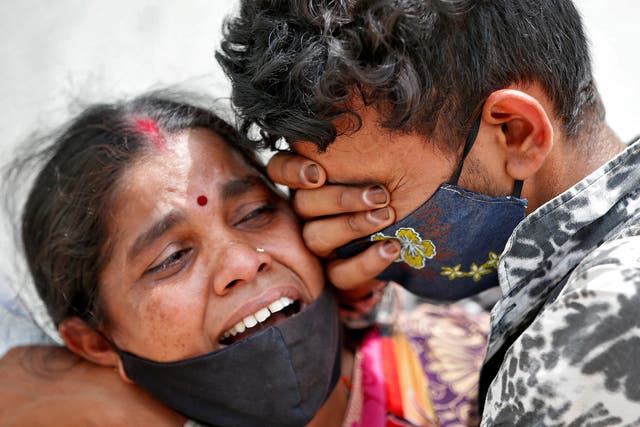 Una mujer llora con su hijo después de que su esposo murió por COVID-19 en Ahmedabad, India