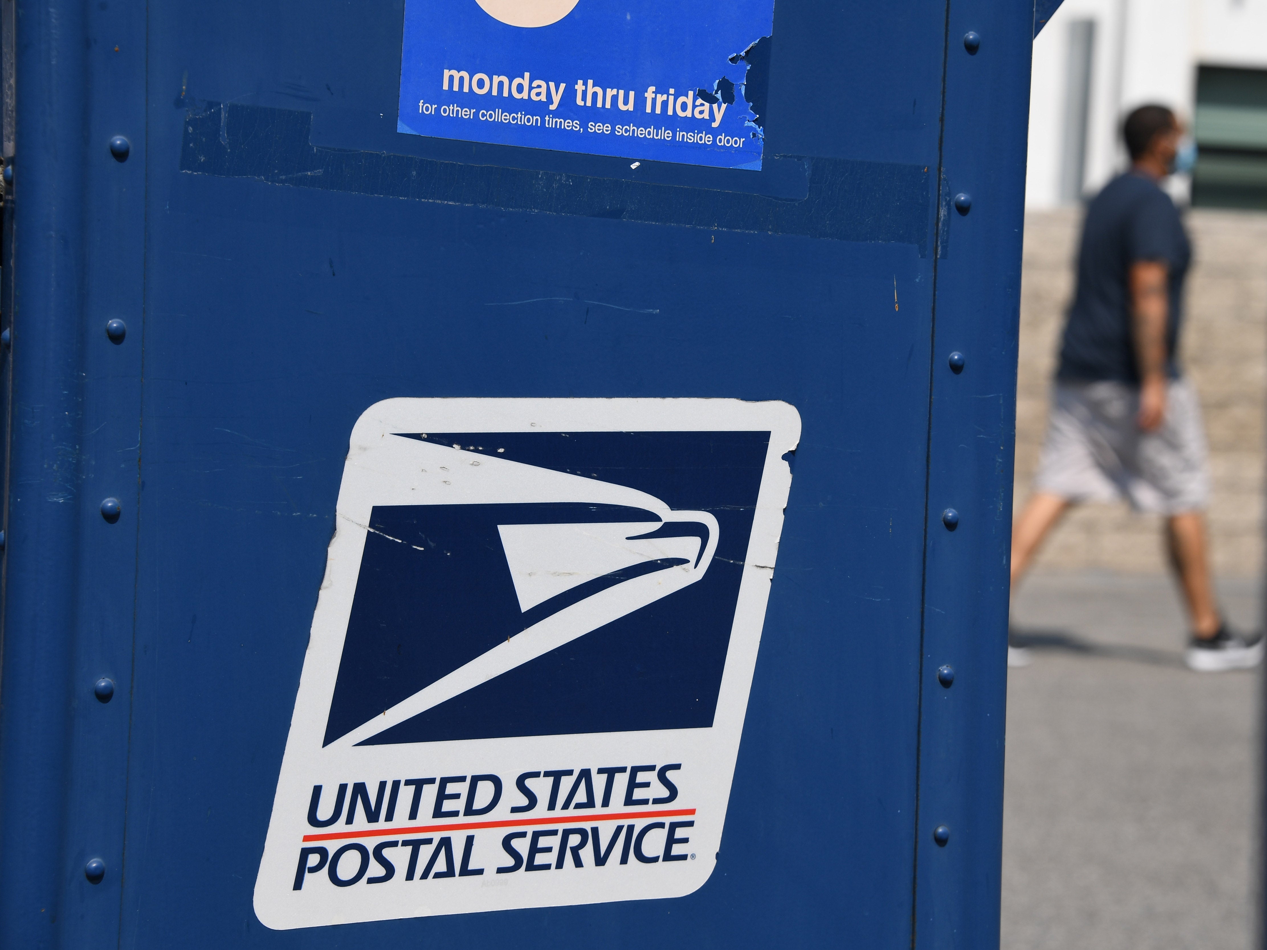 A man walks past a mail box outside a post office in Los Angeles, California on 17 August 2020