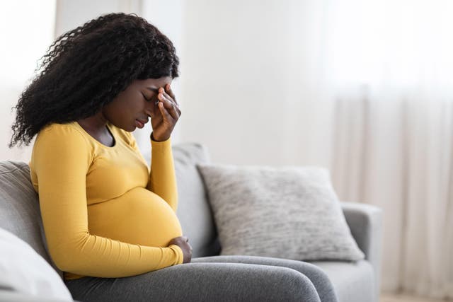 Young pregnant black woman suffering from headache or migraine