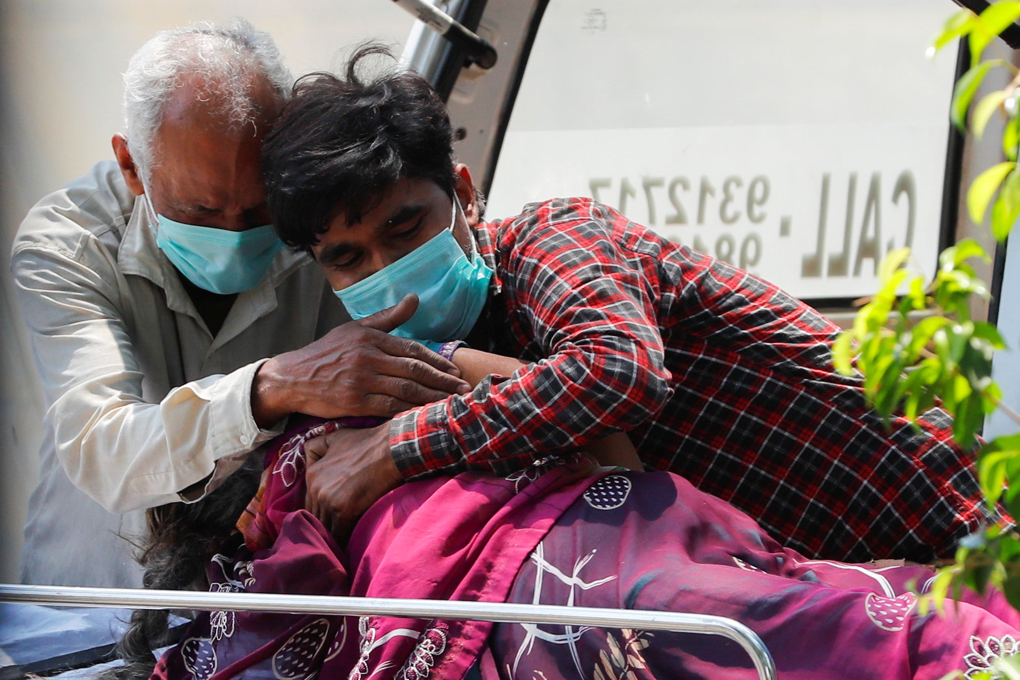 Relatives mourn over the body of a woman, who died from coronavirus, outside Lok Nayak Jai Prakash Narayan hospital, Delhi