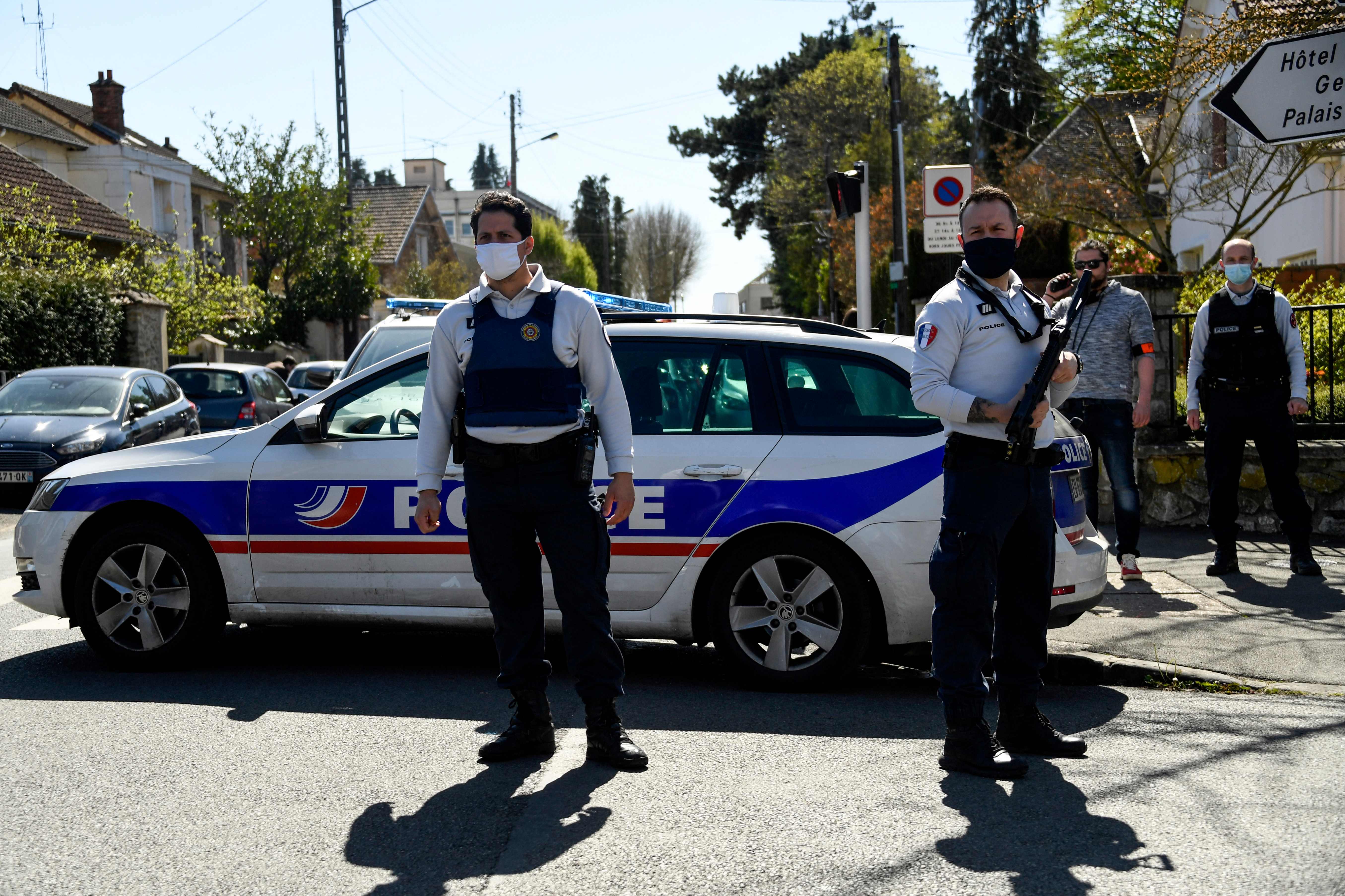 French police officials close a street near a police station in Rambouillet after the fatal stabbing