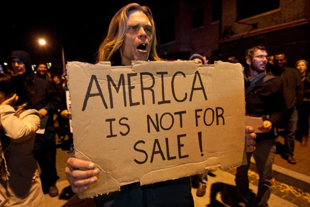 <p>Congress has been urged to act to stop billionaire donors after new analysis found that 12 people contributed $3.4billion to federal campaigns in the last ten years. Pictured a protestor from the Occupy DC march in Washington against the billionaire conservative donor Koch brothers and Americans for Prosperity in 2011</p>