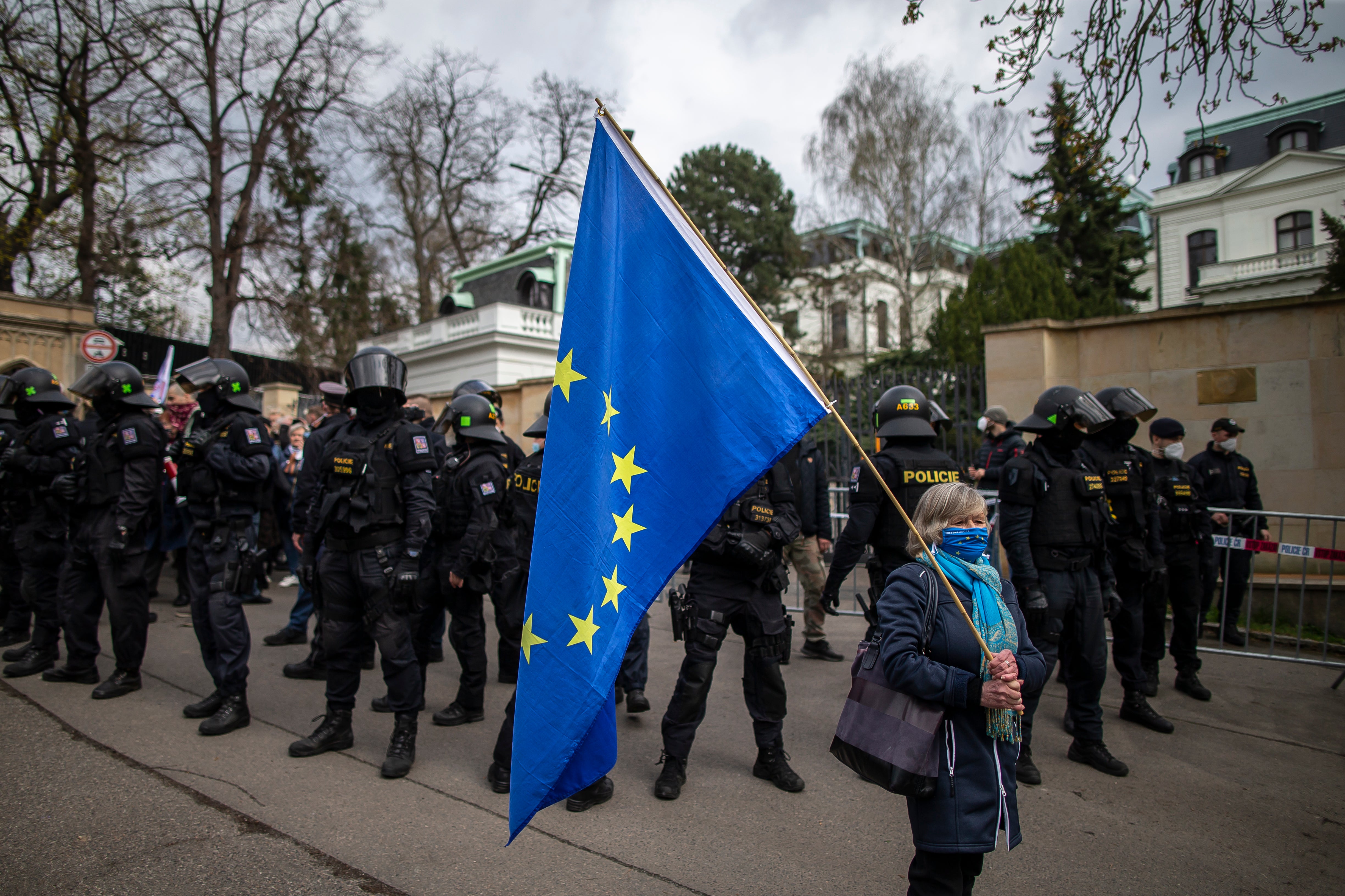 A woman holds an EU flag as people gather to protest outside the Russian Embassy on April 18 in Prague