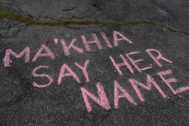 Los partidarios escriben mensajes con tiza en una vigilia en Columbus, Ohio el 21 de abril de 2021 en memoria de MaKhia Bryant, de 16 años, quien fue asesinado a tiros por un oficial del Departamento de Policía de Columbus