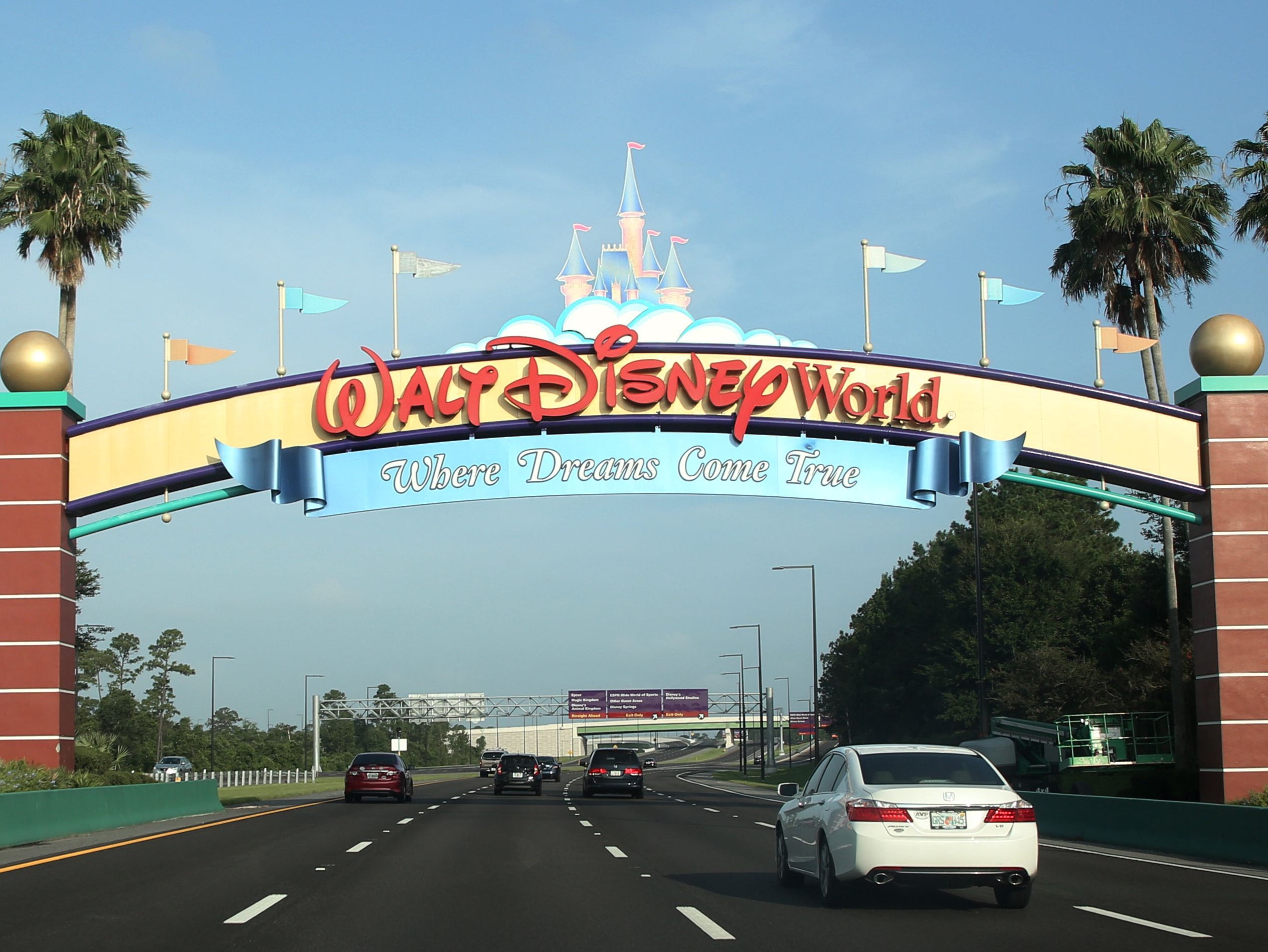 Los visitantes pasan por un letrero que les da la bienvenida a Walt Disney World en el primer día de reapertura del icónico parque temático Magic Kingdom en Orlando, Florida, el 11 de julio de 2020.