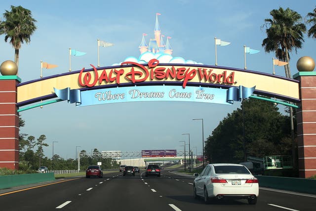 Los visitantes pasan por un letrero que les da la bienvenida a Walt Disney World en el primer día de reapertura del icónico parque temático Magic Kingdom en Orlando, Florida, el 11 de julio de 2020.