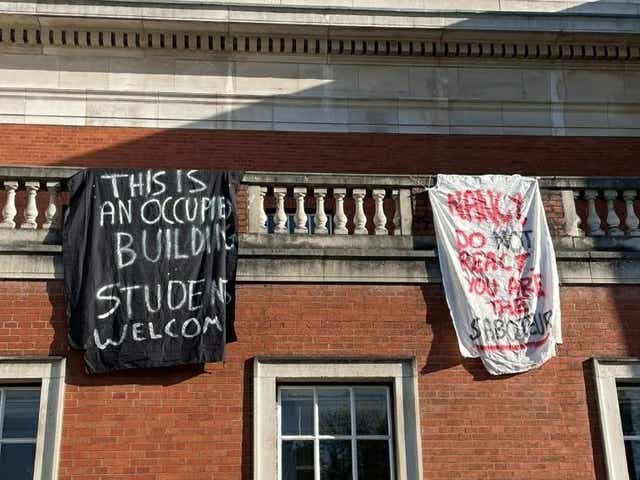 Students at the University of Manchester hang flags out of an occupied building on campus