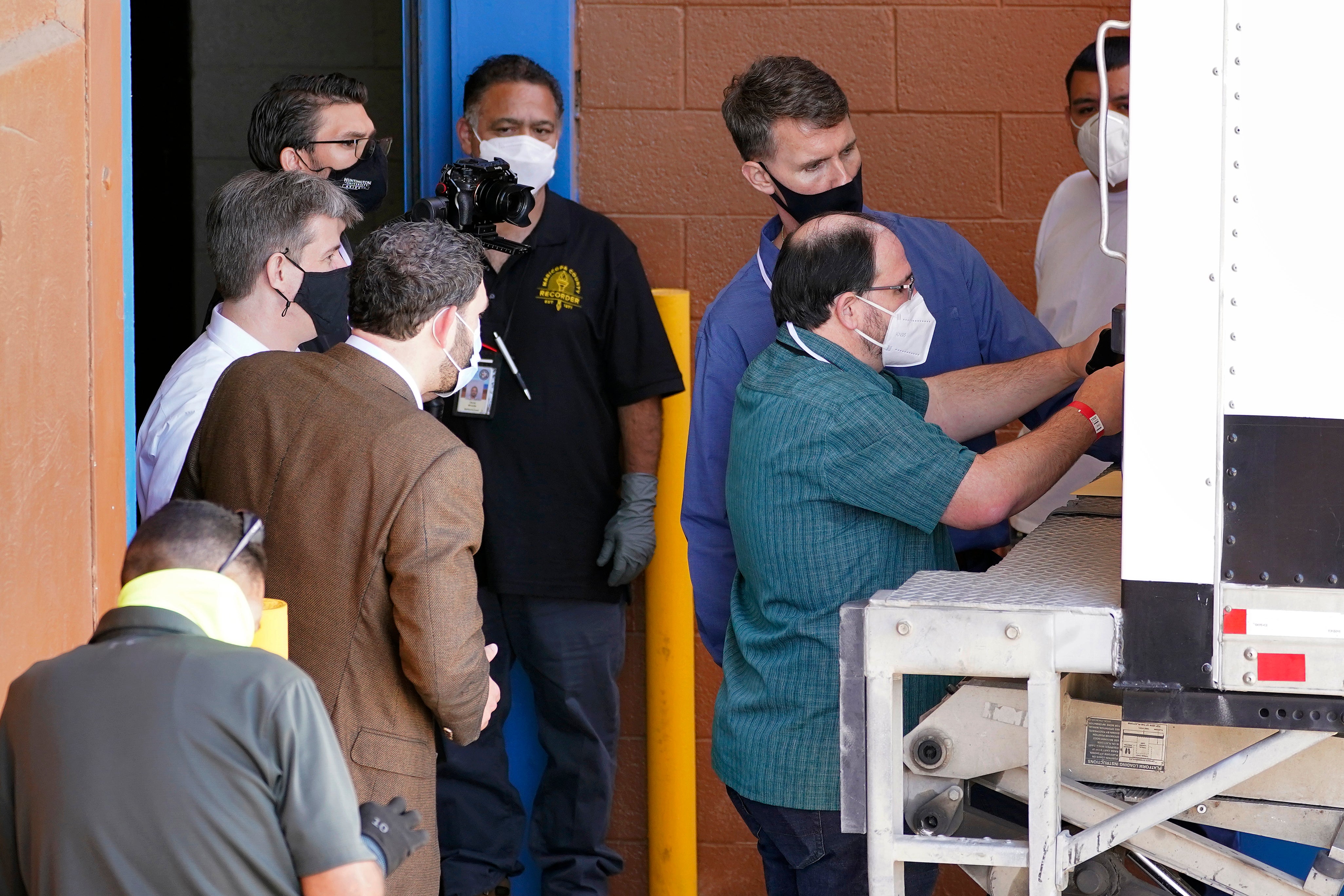 Officials unlock a truck prior to unloading election equipment into the Veterans Memorial Coliseum at the state fairgrounds, Wednesday, April 21, 2021, in Phoenix.