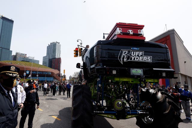 Los miembros de la policía de Nueva York se paran junto al camión monstruo que sostiene el ataúd del rapero estadounidense DMX en la avenida Flatbush, fuera del Barclays Center.