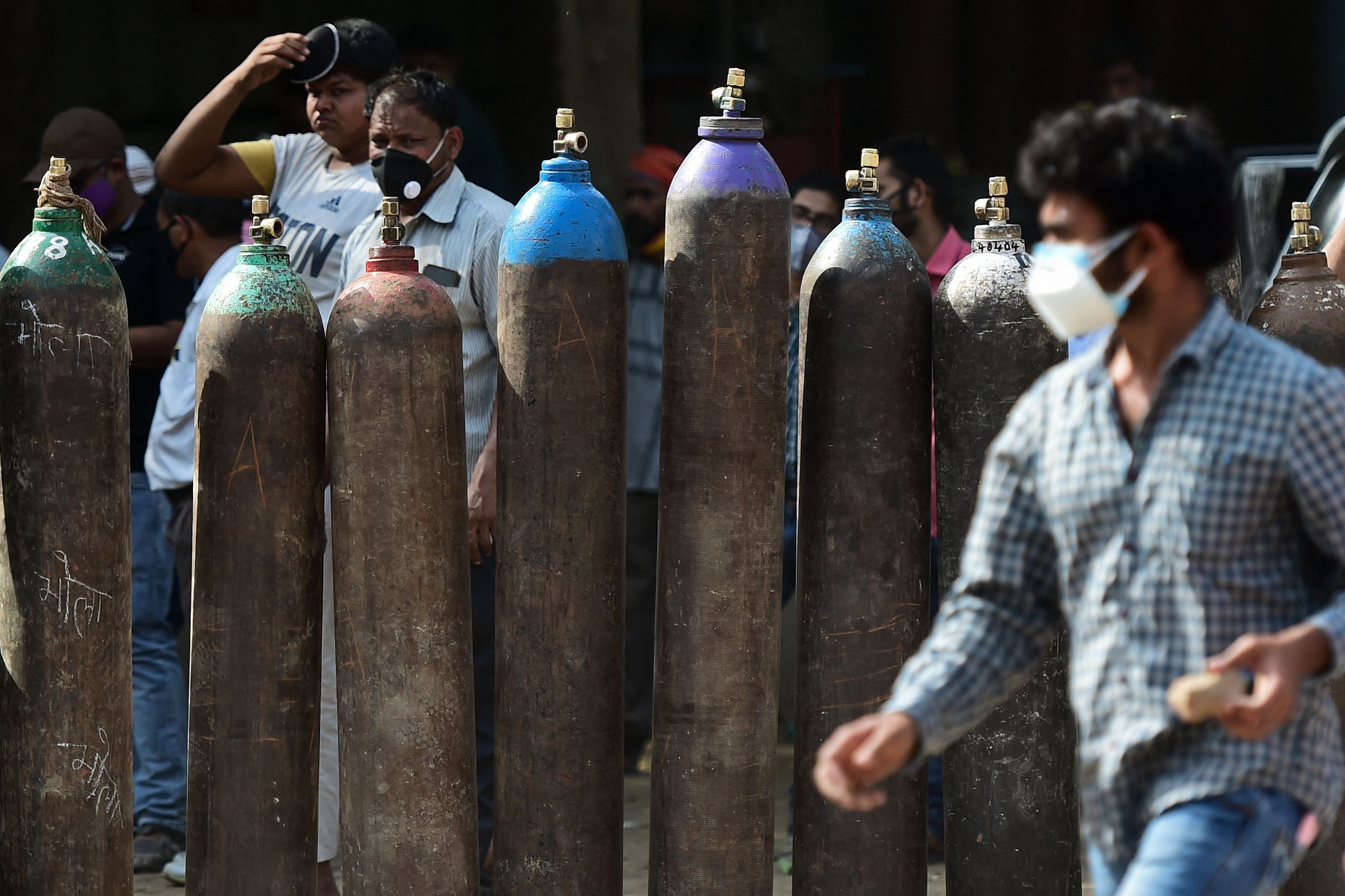 Medical workers wait to refill oxygen cylinders in Allahabad