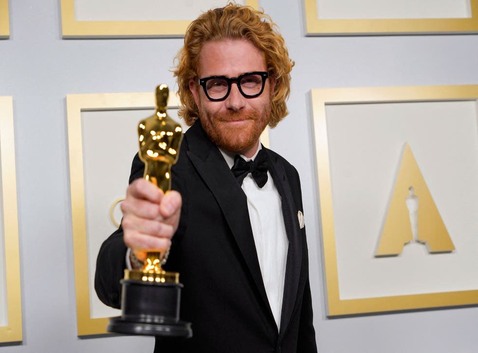 <p>Cinematographer Erik Messerschmidt poses in the press room with the award for Cinematography for ‘Mank’</p>